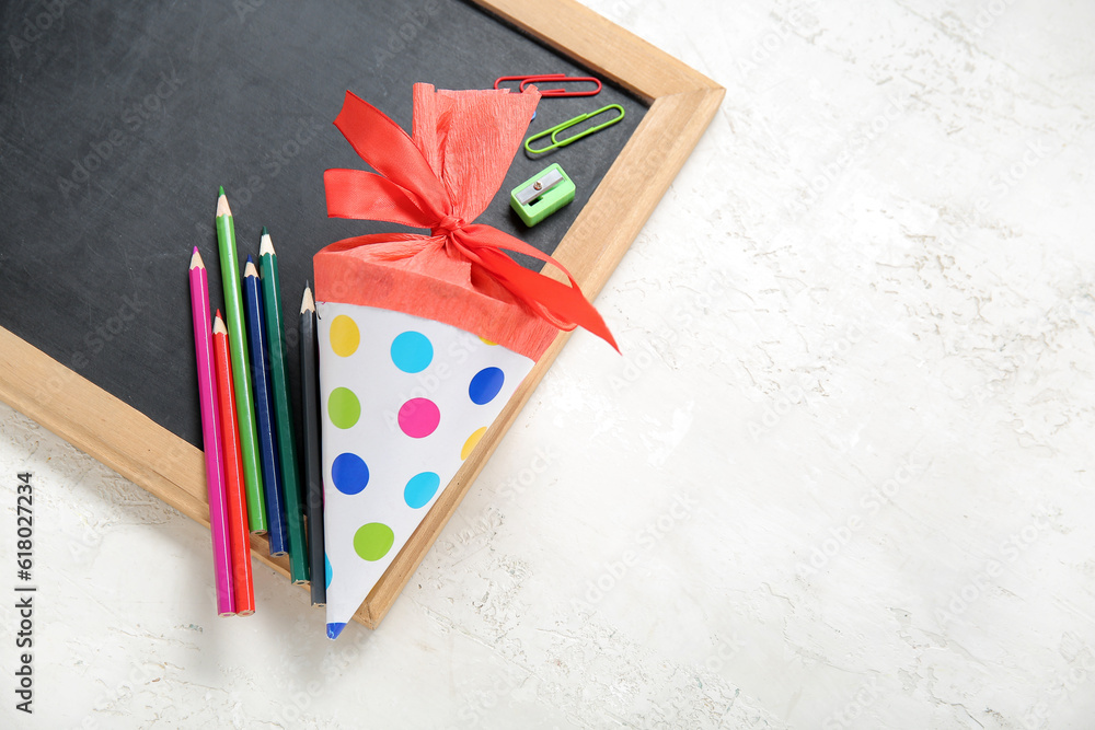 Red school cone with different stationery and blackboard on white background