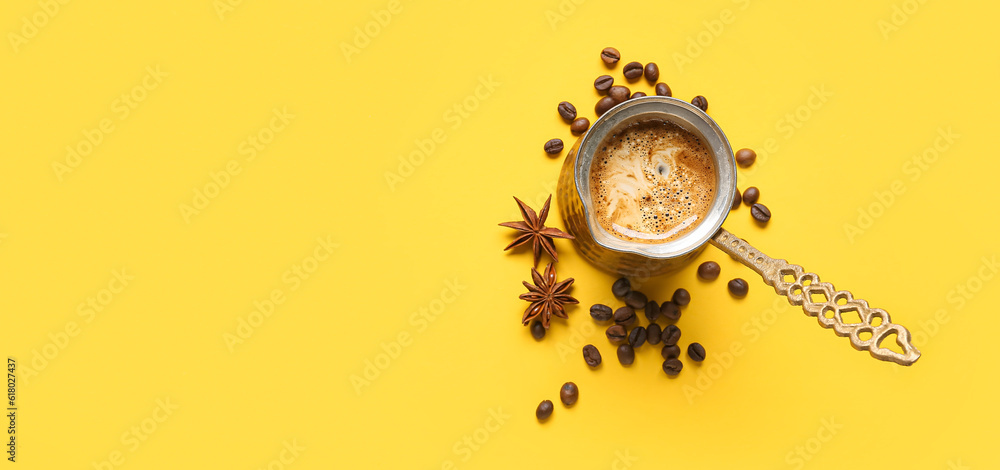 Cezve with coffee, beans and star anise on yellow background