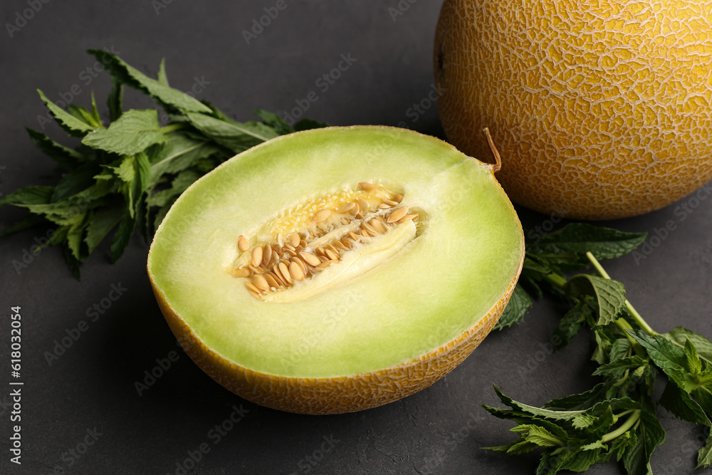 Sweet melon with half and mint on black background