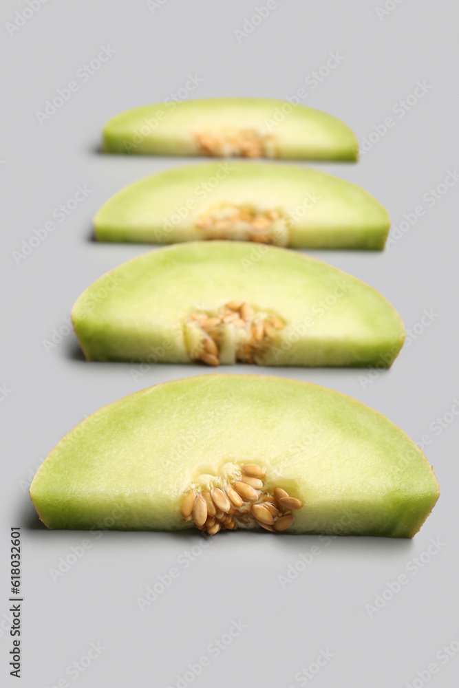 Pieces of sweet melon on grey background