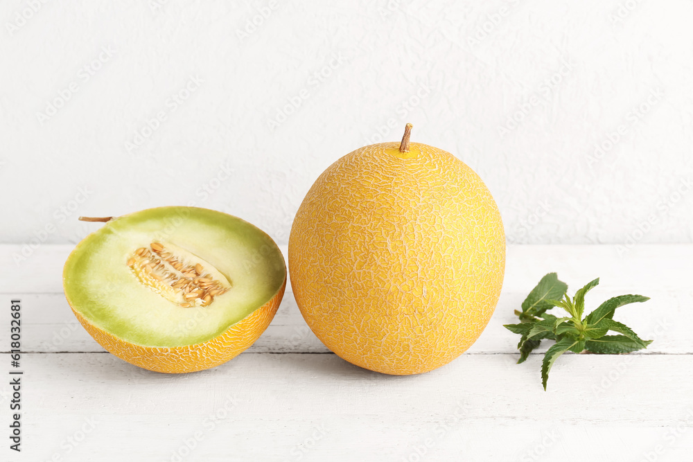 Sweet melon with half and mint on white wooden table