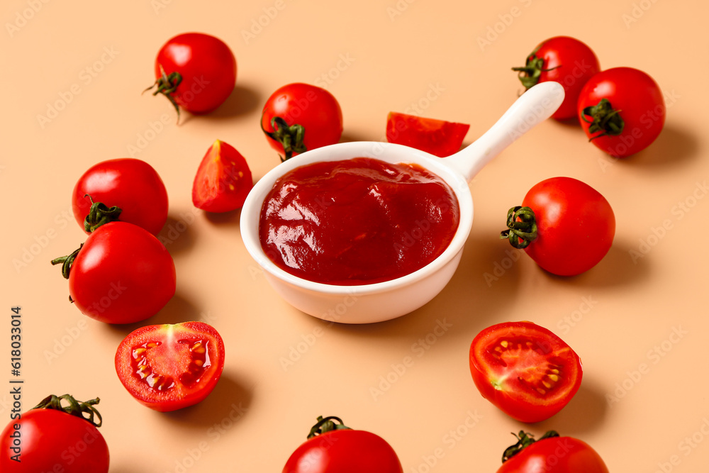 Bowl with tomato paste and fresh vegetables on orange background