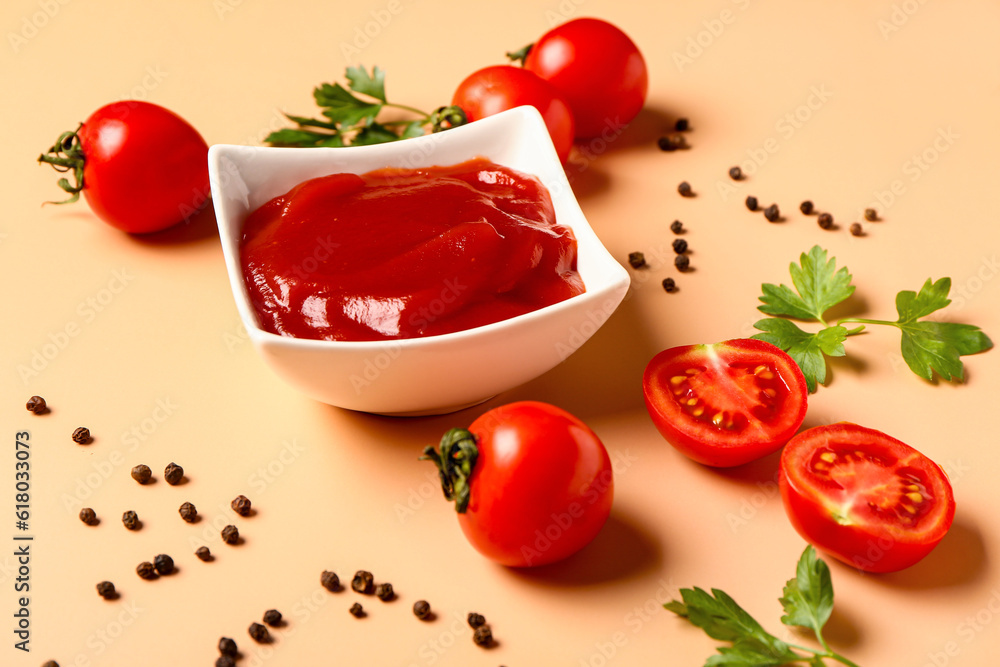 Bowl with tomato paste and fresh vegetables on orange background