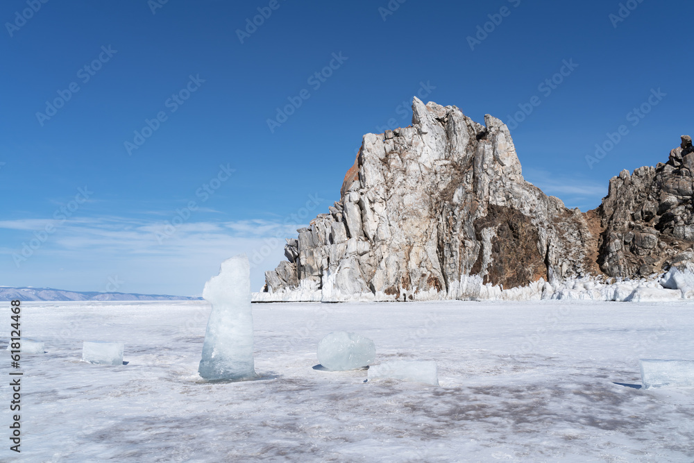 Beautiful winter landscape with blue ice cave grotto and frozen clear icicles. Lake Baikal, Russia. 