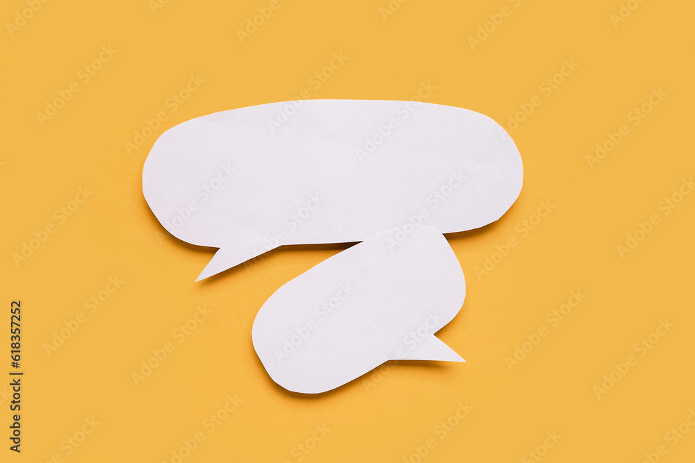 Blank paper speech bubbles on orange background