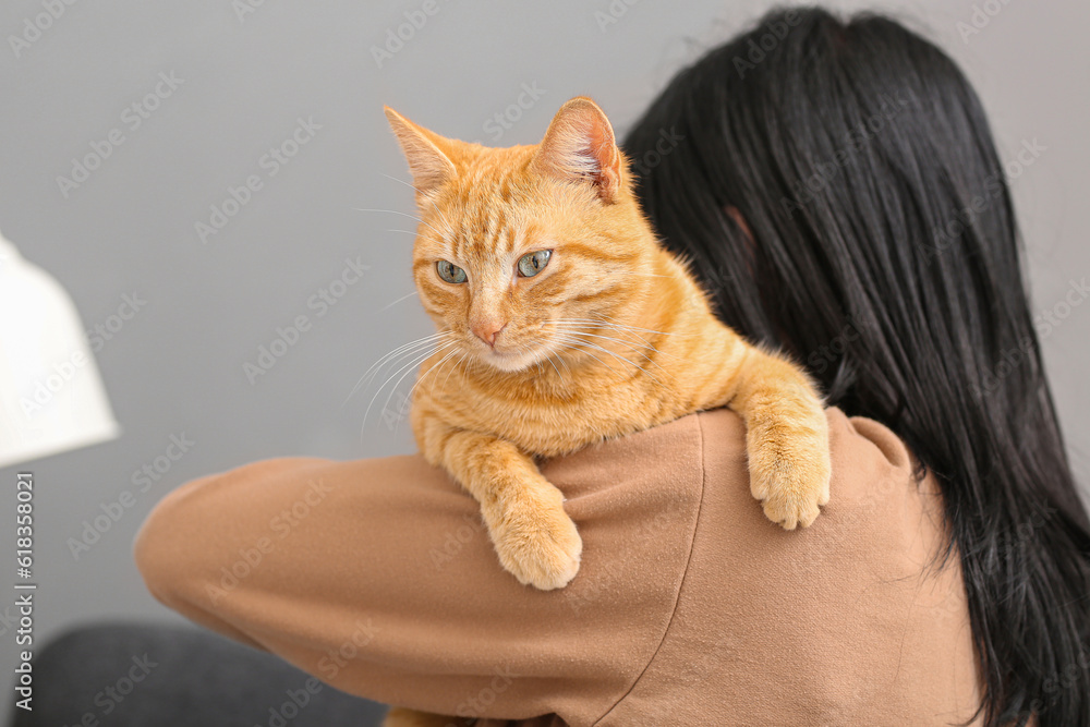 Woman with ginger cat at home, closeup