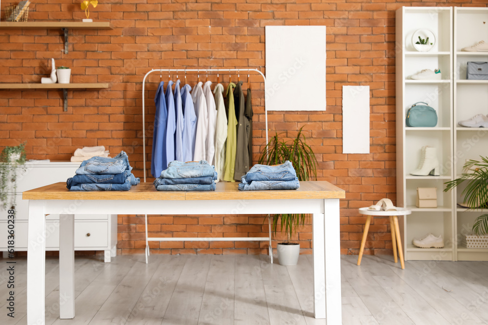 Table with stylish jeans pants in modern boutique