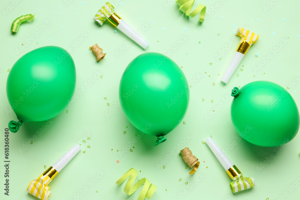 Balloons and whistles for birthday party on pale green background