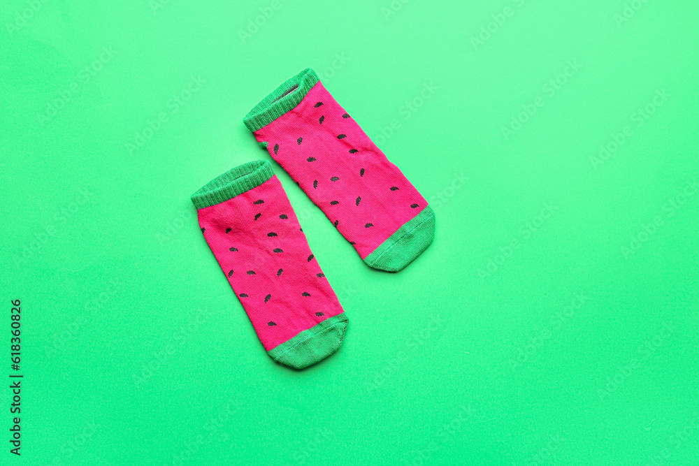 Pair of colorful cotton socks on green background