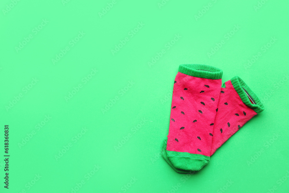 Pair of colorful cotton socks on green background