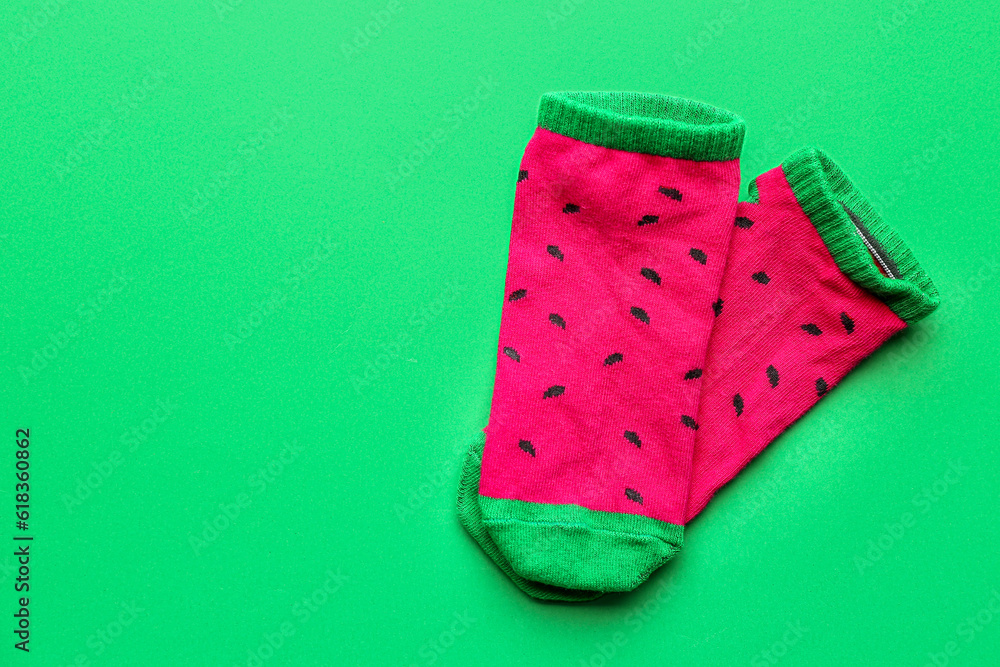 Pair of colorful cotton socks on green background