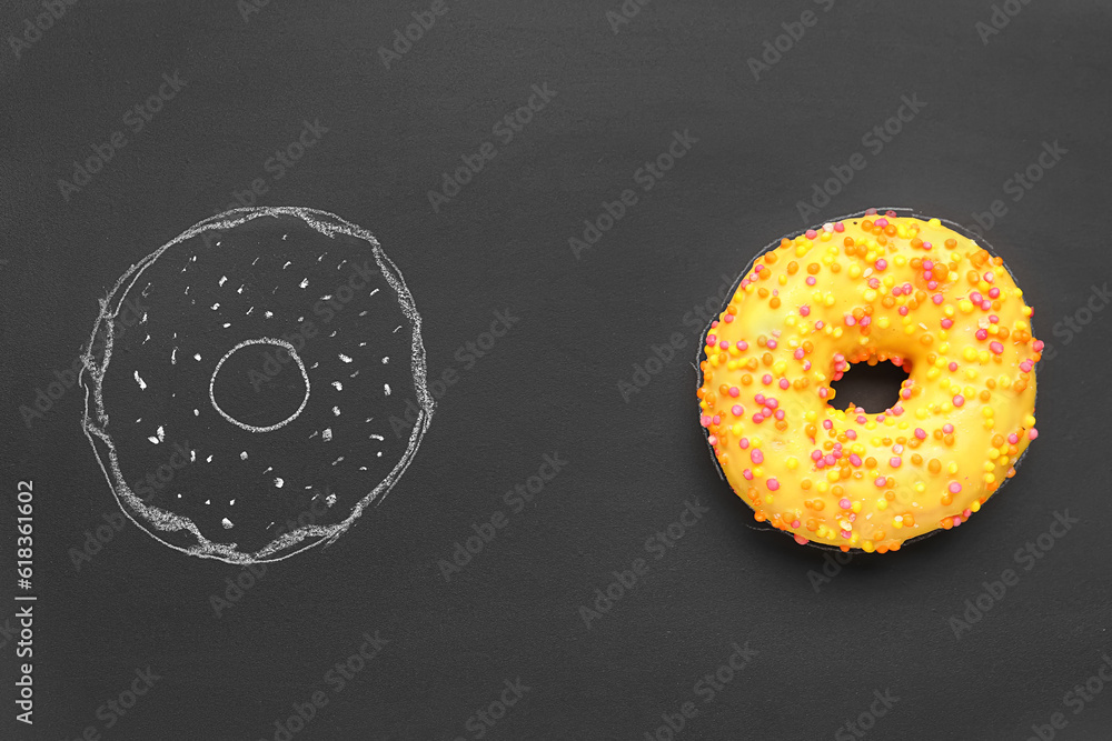 Fresh and drawn donuts on black background