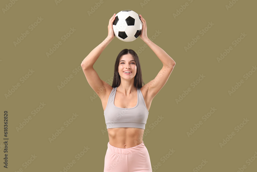 Sporty young woman with soccer ball on color background