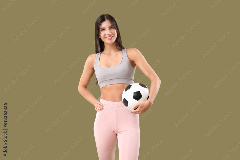 Sporty young woman with soccer ball on color background