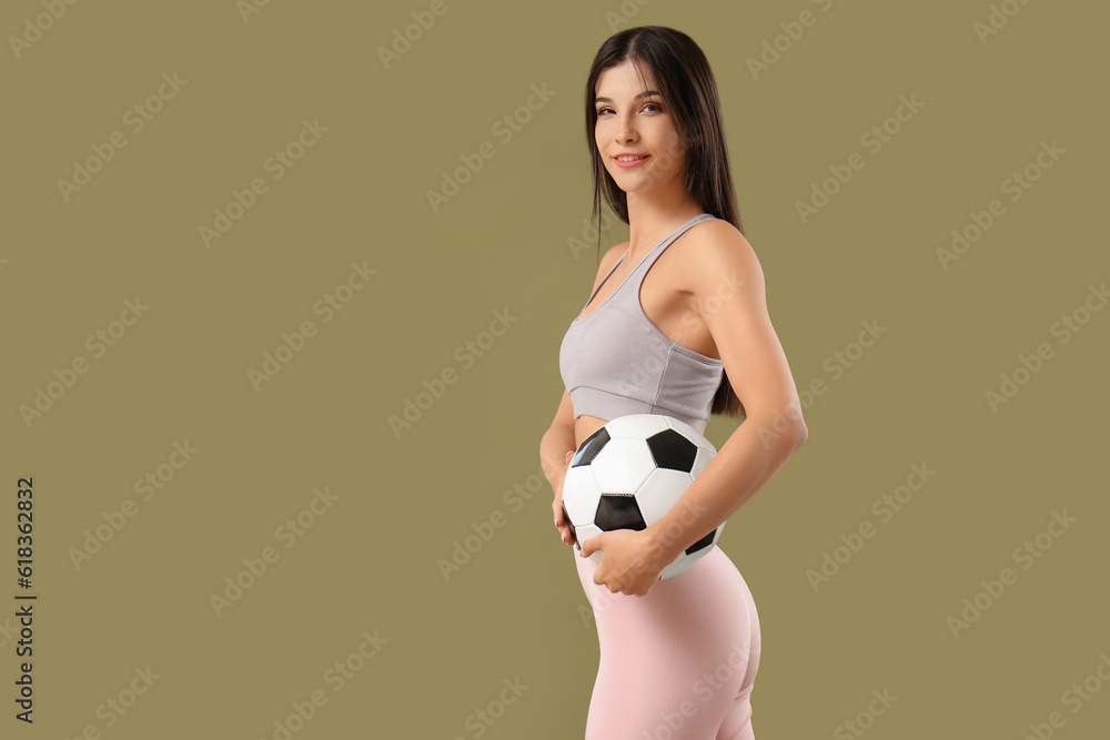 Sporty young woman with soccer ball on color background