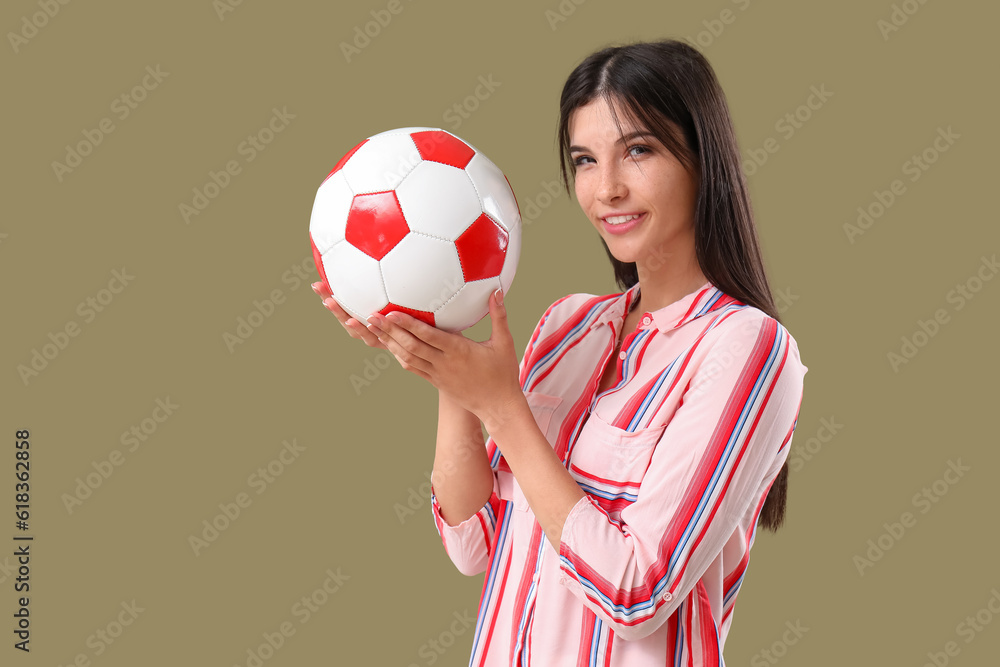 Young woman with soccer ball on color background