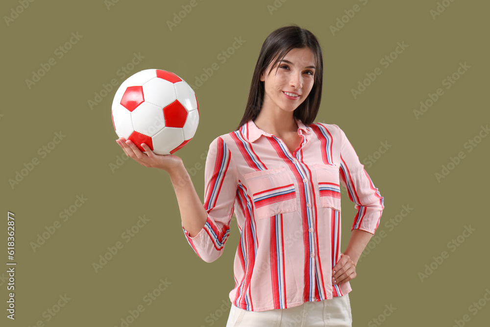 Young woman with soccer ball on color background