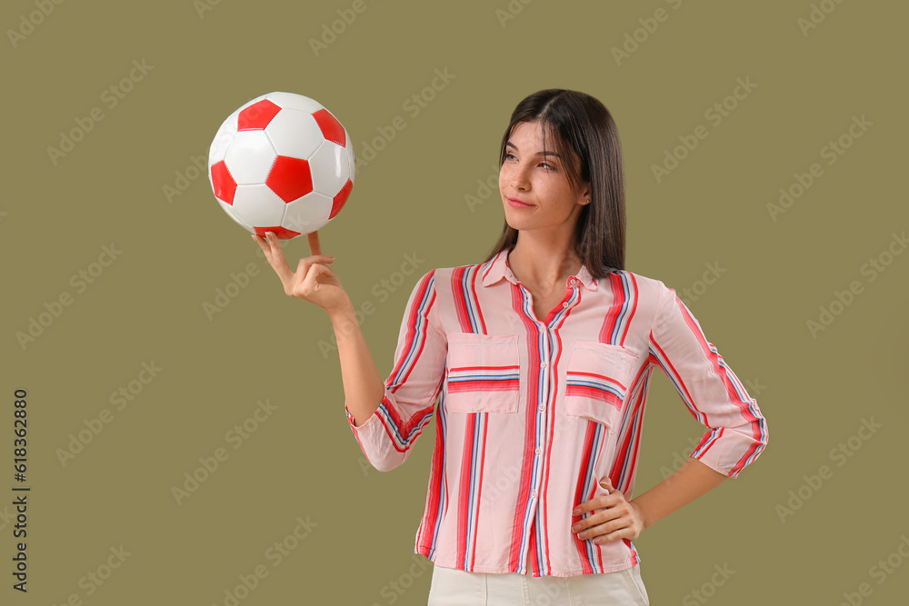 Young woman with soccer ball on color background