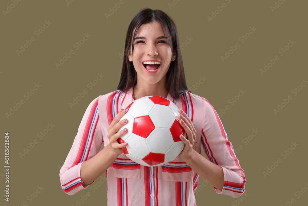 Happy young woman with soccer ball on color background