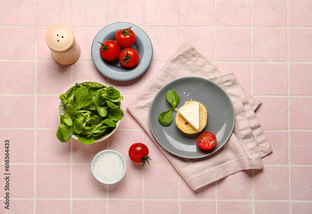 Crouton with triangle of tasty processed cheese, spinach and tomatoes on pink tile background