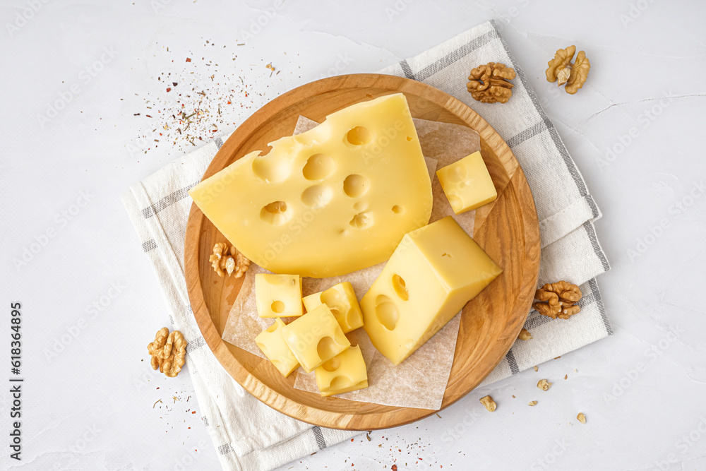 Plate with pieces of Swiss cheese and walnut on white background