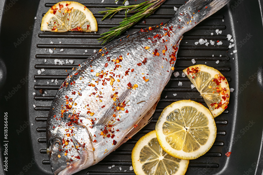 Raw dorado fish with lemon on grill pan