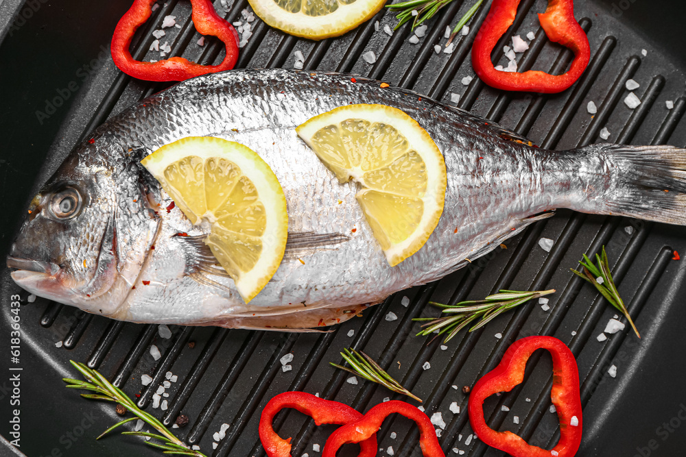 Raw dorado fish with lemon on grill pan