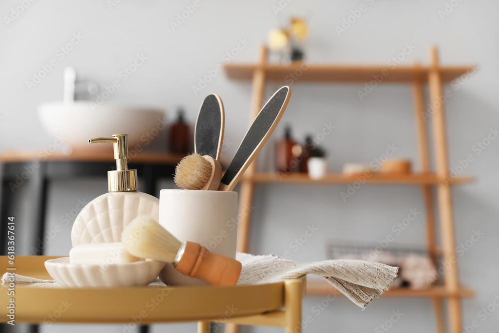 Soap bar, dispenser, shaving brush and bath accessories on table in bathroom, closeup