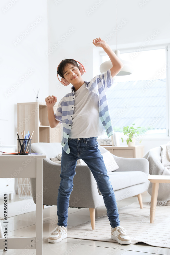 Little boy in headphones dancing at home