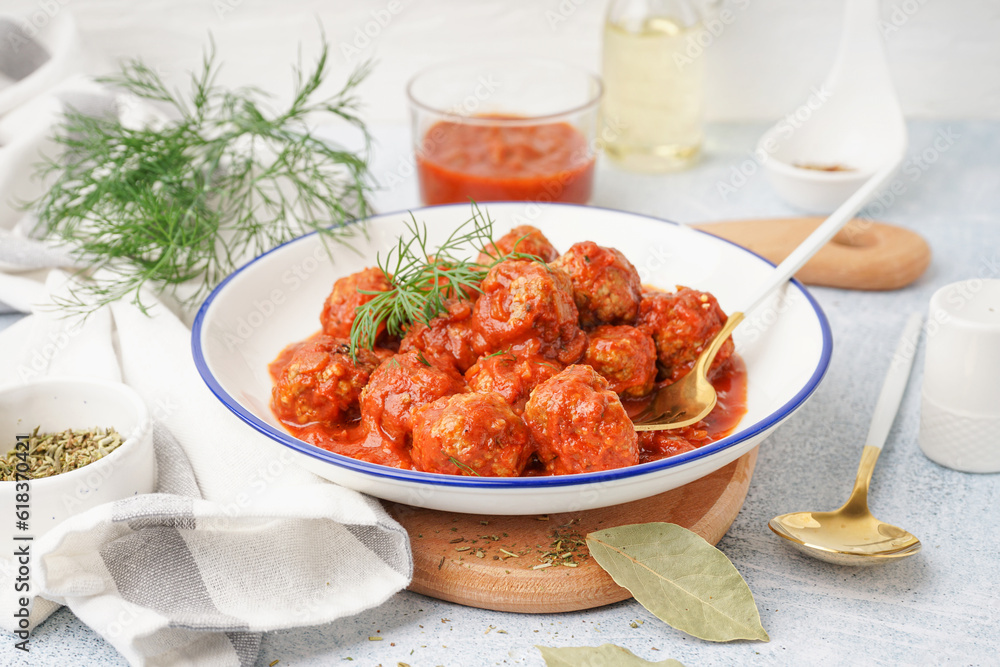 Bowl of tasty meat balls with tomato sauce and dill on white background