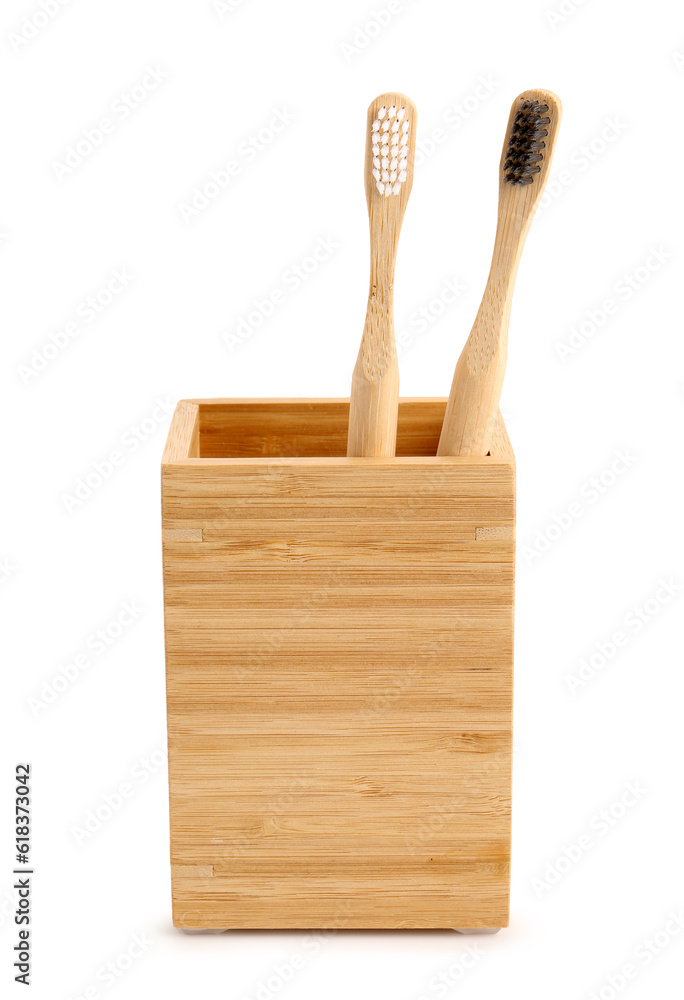 Bamboo tooth brushes in holder on white background