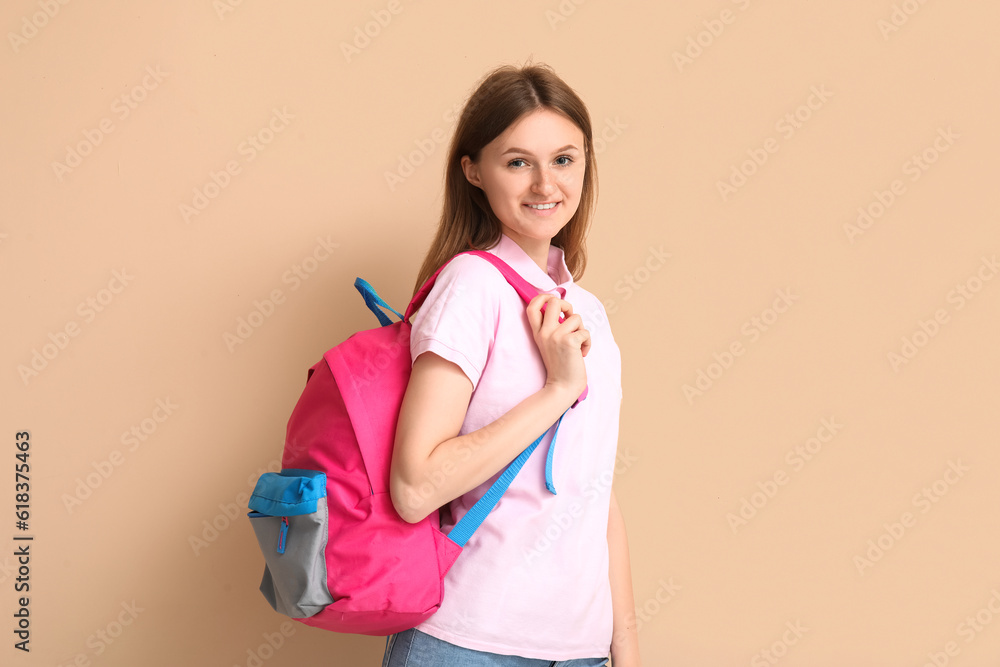 Female student with backpack on beige background