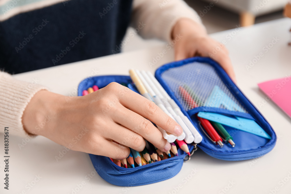 Female student with pencil case at table, closeup