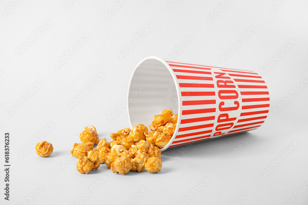 Bucket with tasty popcorn on grey background