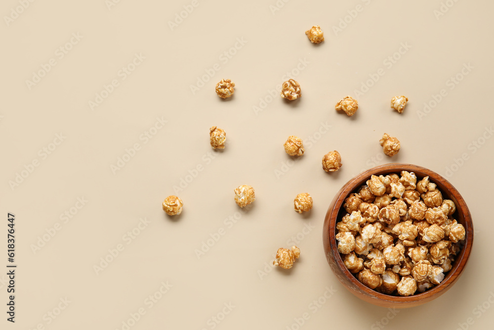 Bowl with tasty popcorn on beige background