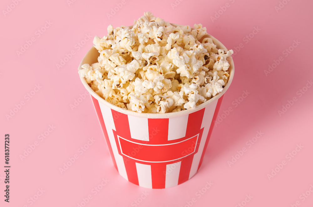 Bucket with tasty popcorn on pink background