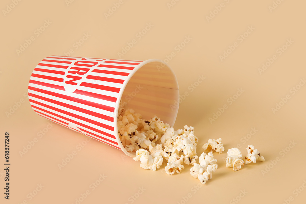 Bucket with tasty popcorn on beige background