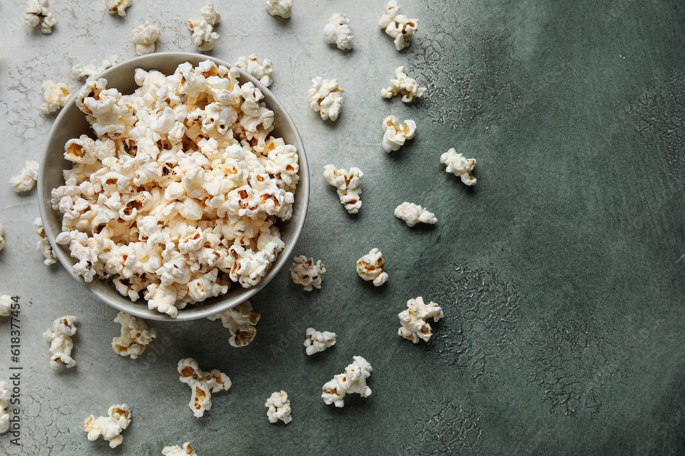 Bowl with tasty popcorn on grey background