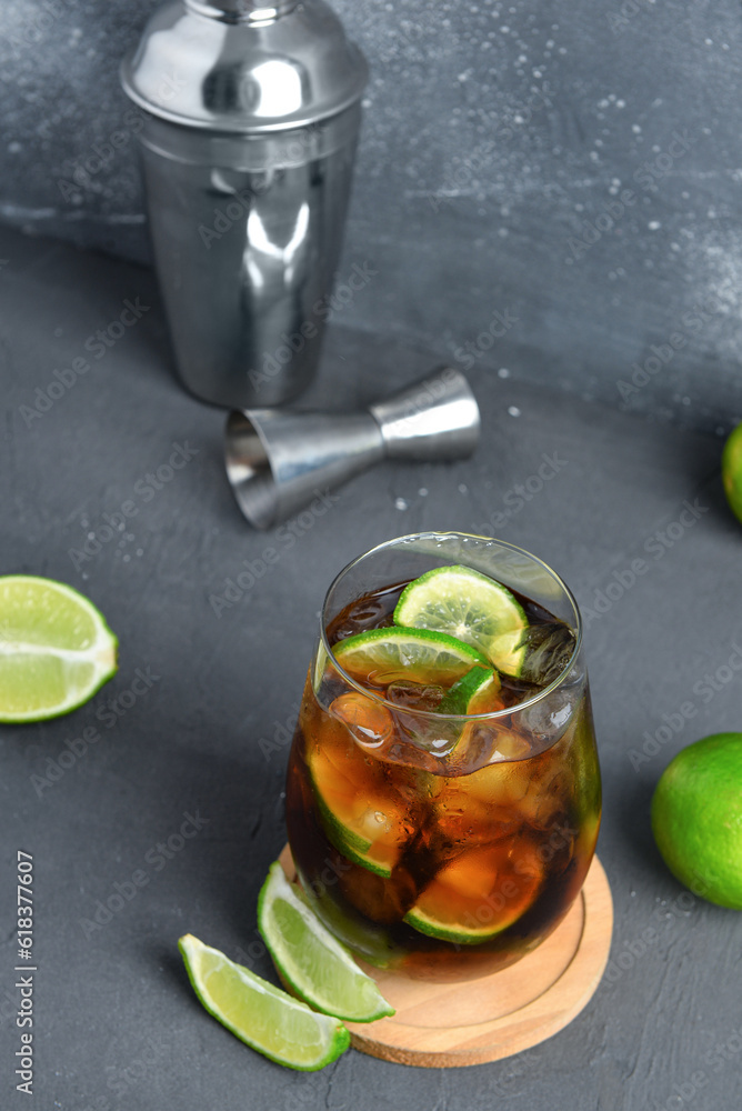 Glass of cold Cuba Libre cocktail on grey background