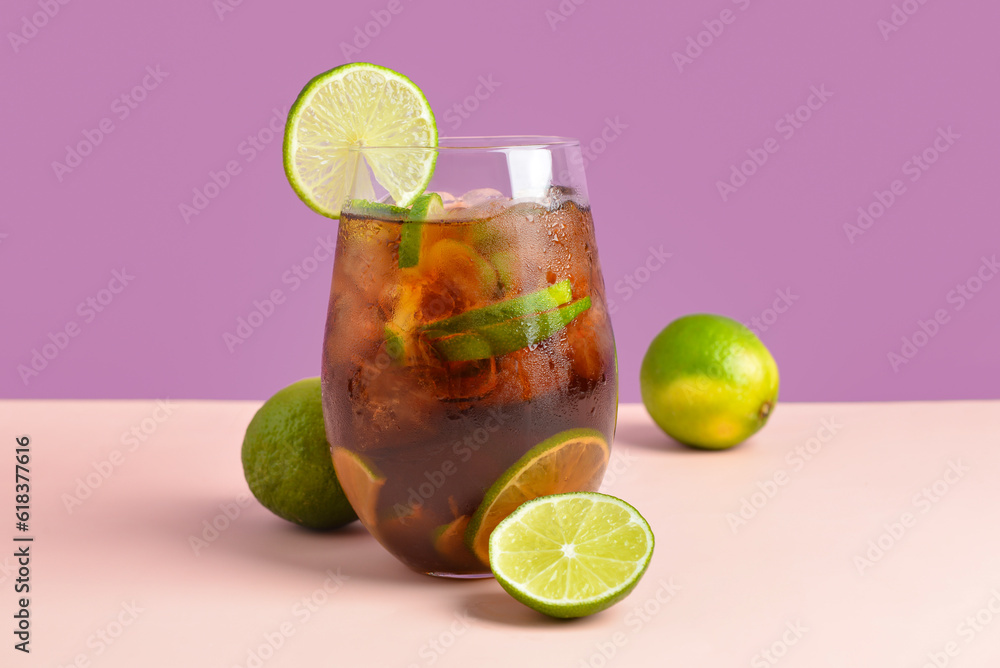 Glass of cold Cuba Libre cocktail on color background