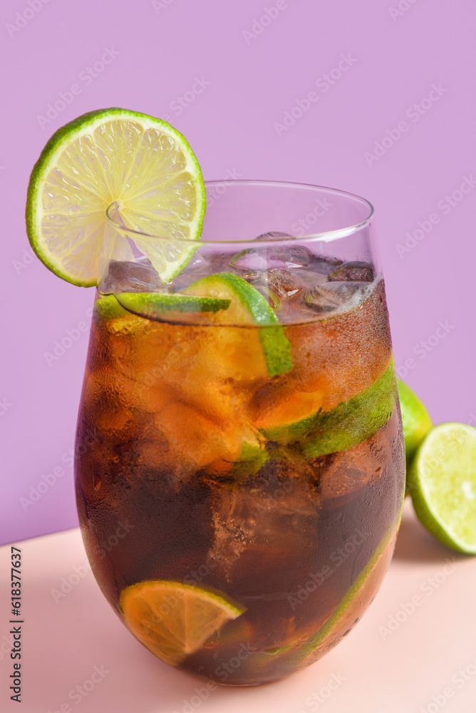 Glass of cold Cuba Libre cocktail on color background