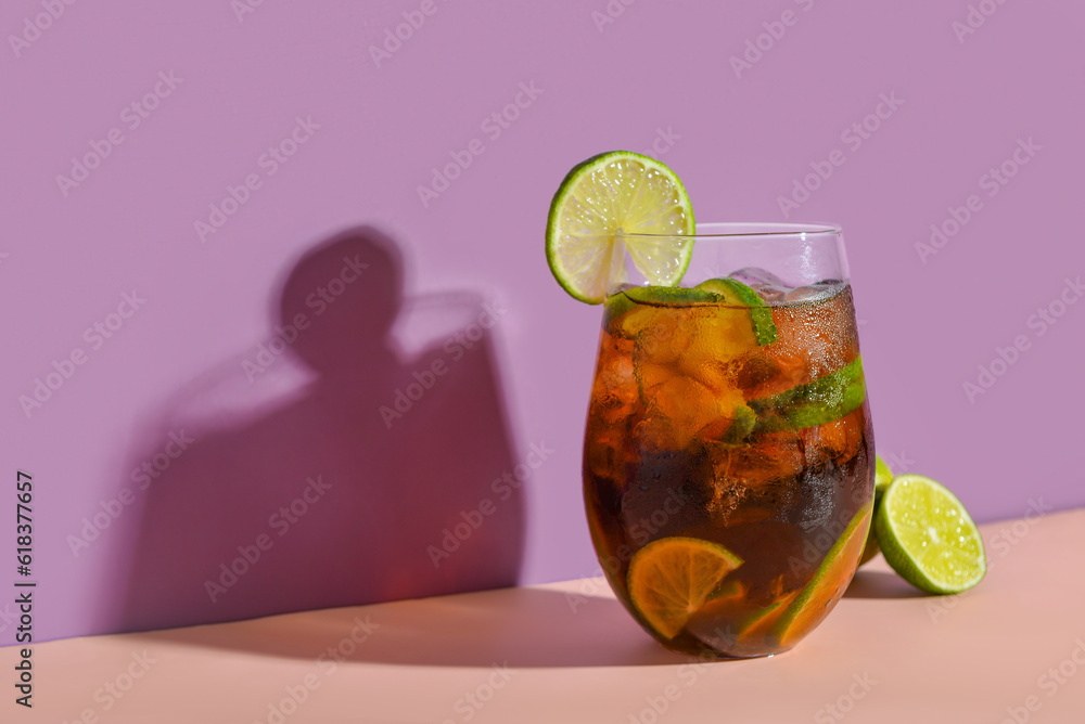 Glass of cold Cuba Libre cocktail on color background