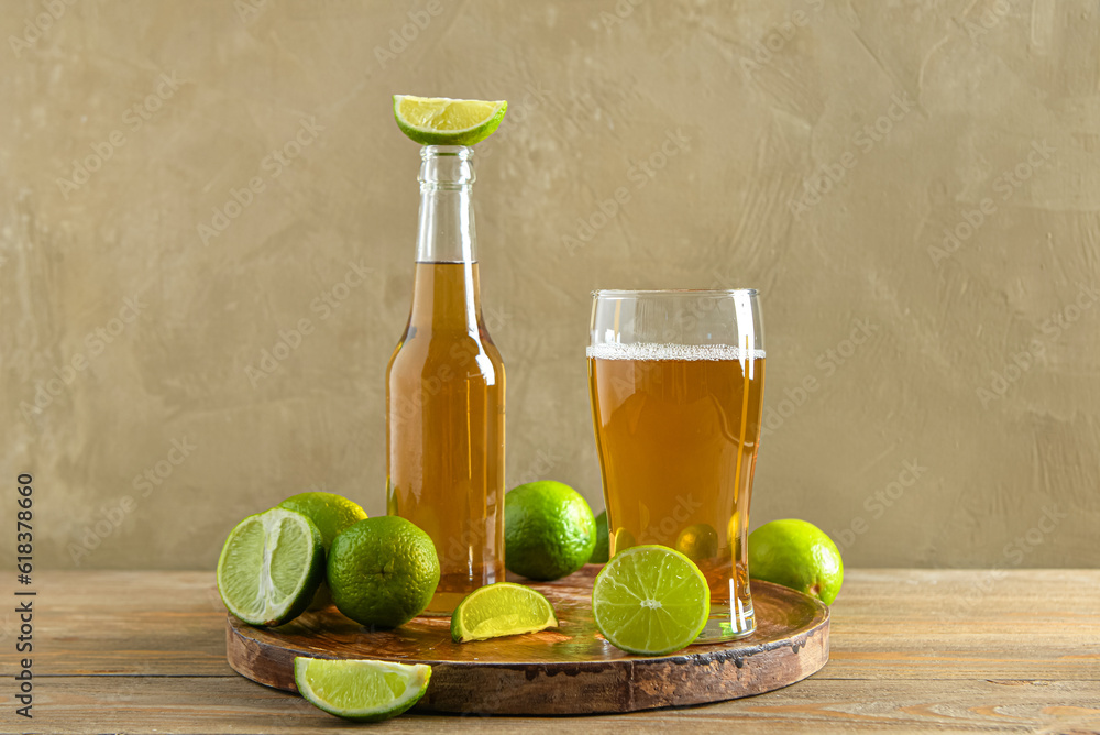 Glass and bottle of cold beer with lime on table