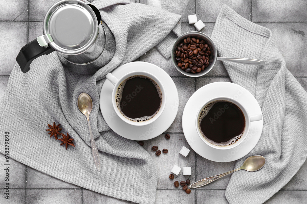 Composition with cups, coffee maker, fabric and beans on tile background