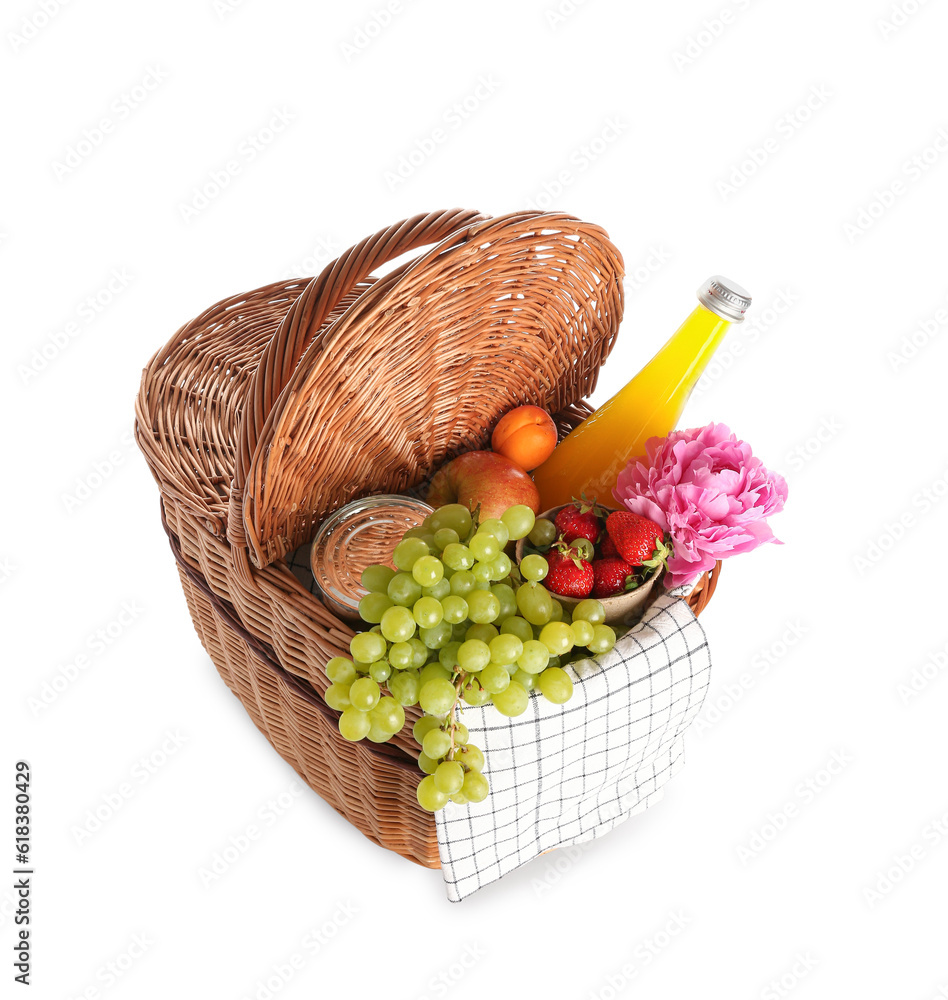 Wicker basket with tasty food for picnic, juice and peony flower on white background