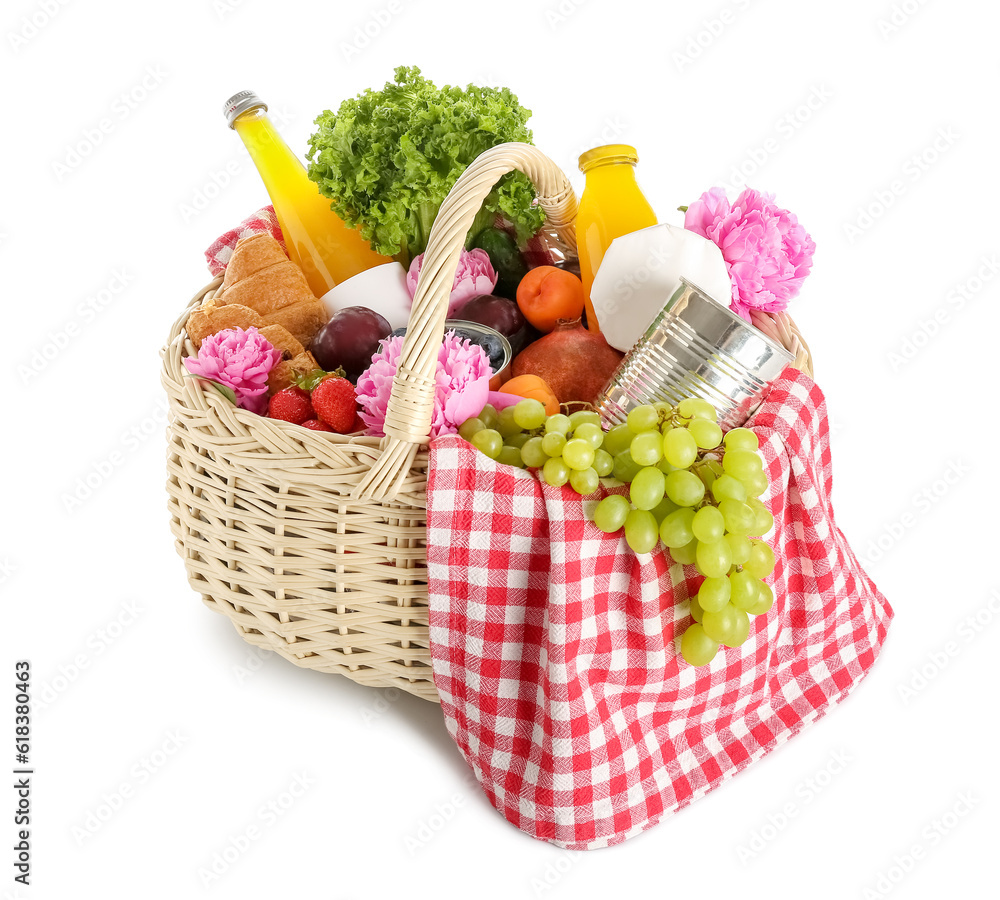 Wicker basket with tasty food for picnic, juice and peony flowers on white background