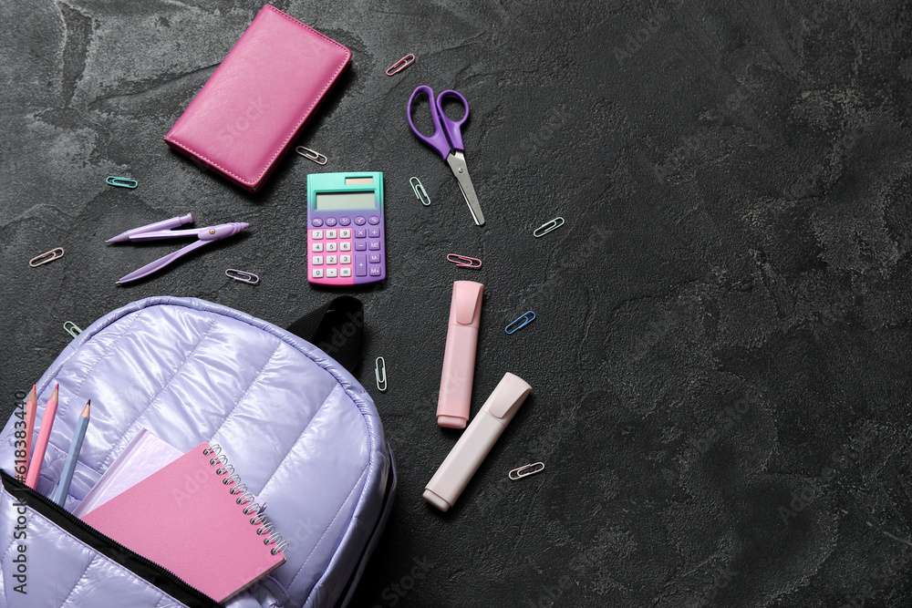 Lilac school backpack with calculator, notebooks and scissors on black background