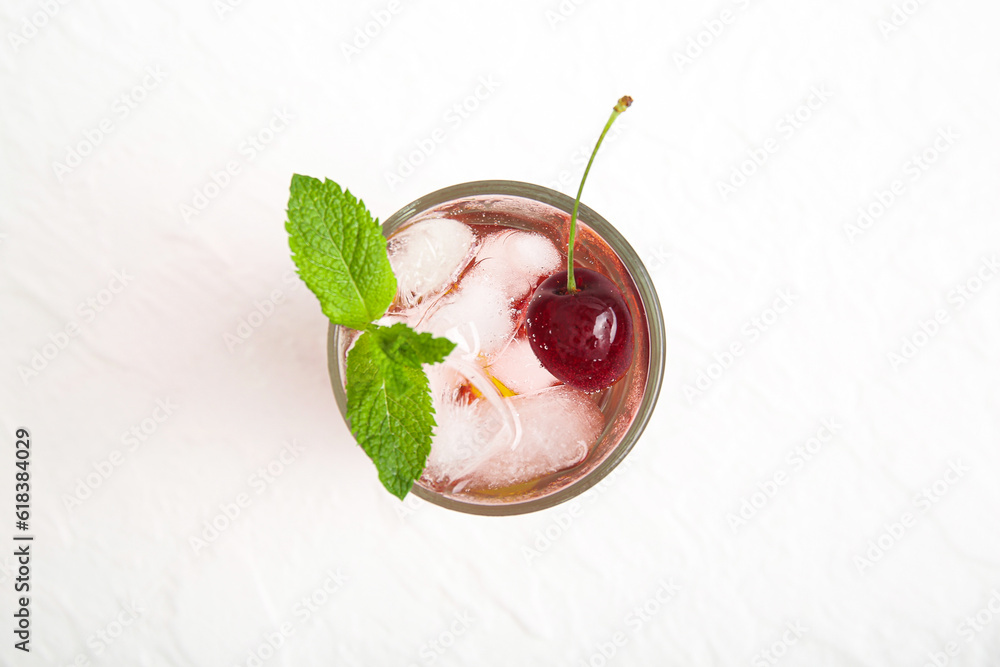 Glass of tasty cherry lemonade with mint on white background