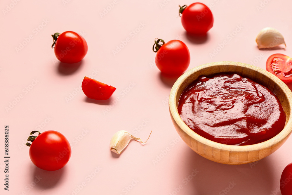 Bowl with tomato paste and fresh vegetables on pink background