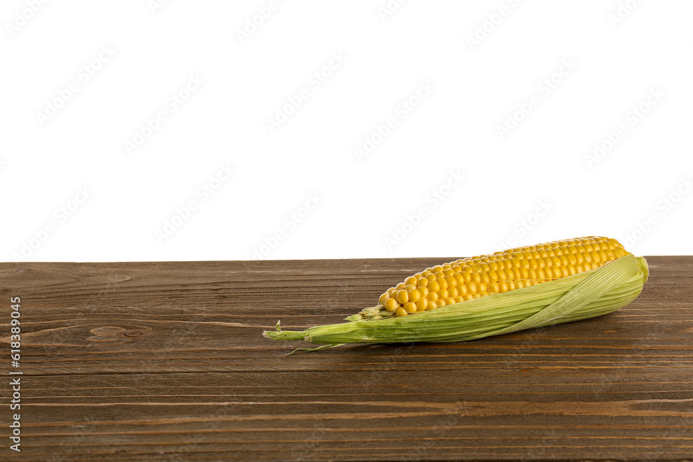 Fresh corn cob on wooden table against white background